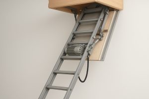 A close-up view of an electric loft ladder partially extended from the ceiling, showcasing its mechanical components.