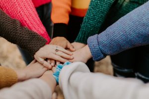Several hands of different individuals coming together in a collaborative gesture